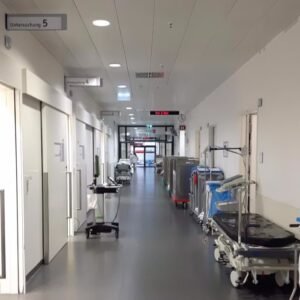 Pasillo de hospital con camillas y equipos médicos
